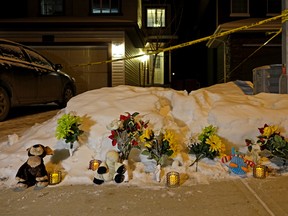 Flowers, candles and stuffed animals were placed in front of a home in Edmonton where seven bodies were discovered on December 30, 2014.