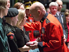 RCMP Commissioner Bob Paulson hands the flag from slain RCMP Constable David Wynn's casket to Wynn's wife Shelly MacInnis-Wynn in St. Albert, Alta., on Monday, January 26, 2015.