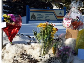 Several bouquets of flowers have been left in the snow outside the St. Albert RCMP headquarters a day after two officers were shot at the Apex Casino on Jan. 17, 2015.
