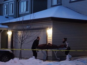 One of seven bodies is removed from a home in Edmonton on Dec. 30, 2014. The murder weapon was a 9 mm handgun, say police.