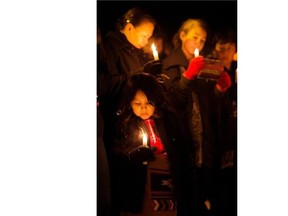 People take part in a candlelight vigil on Dec. 25, 2014 near where a six-year-old girl was found beaten on the Paul First Nation near Duffield, west of Edmonton.