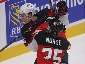 Canada's Darnell Nurse takes out Brandon Carlo of USA during the North American rivals' New Year's Eve clash at Centre Bell.
