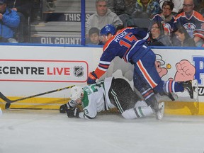 Rough-and-tumble  winger Tyler Pitlick clobbers Alex Goligoski of Dallas Stars in a recent Oilers game.