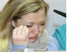 Shelly MacInnis-Wynn, wife of RCMP Const. David Matthew Wynn, breaks down in tears while speaking about her husband at RCMP K Division in Edmonton on Jan. 19, 2015. Wynn, a 42-year-old father of three, was one of two RCMP officers shot by Shawn Rehn on Saturday Jan. 17, 2015. He remains in hospital in critical condition. RCMP auxiliary Constable Derek Walter Bond, 49-years-old, was shot in the arm and torso. He was released from hospital but faces a long recovery. Rehn was found dead inside an abandoned home he had broken into.