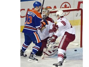 Steven Pinizzotto (13) scores on goalie Devan Dubnyk (40) with Zbynek Michalek (4) in front as the Edmonton Oilers play the Arizona Coyotes at Rexall Place in Edmonton, December 23, 2014.