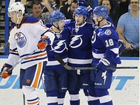 Tampa Bay Lightning left wing Ondrej Palat (18), of the Czech Republic, celebrates his goal against the Edmonton Oilers with teammates right wing Nikita Kucherov (86), of Russia, and center Tyler Johnson (9) during the third period of an NHL hockey game Thursday, Jan. 15, 2015, in Tampa, Fla. Oilers’ Mark Fayne (5) skates off.