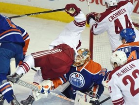 Joe Vitale (14) goes over goalie Viktor Fasth (35) as the Edmonton Oilers play the Arizona Coyotes at Rexall place in Edmonton, December 23, 2014.