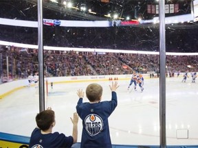 Two young hockey fans try to get a closer look during the Edmonton Oilers’ skills competition on Sunday at Rexall Place.