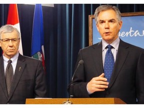 Alberta Premier Jim Prentice speaks during a news conference as Finance Minister Robin Campbell, left, looks on in Edmonton on Wednesday Feb. 11, 2015. Prentice and Campbell announced the province is looking at a nine-per-cent cut to departmental spending in the next budget, due to the collapse in oil prices.