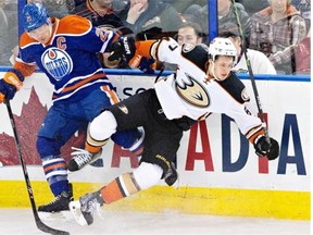 Anaheim Ducks’ Rickard Rakell (67) is checked by Edmonton Oilers’ Andrew Ference (21) during third period NHL hockey action in Edmonton, Alta., on Feb. 21, 2015.