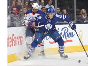 Boyd Gordon #27 of the Edmonton Oilers is knocked off the puck by Korbinian Holzer #55 ofthe Toronto Maple Leafs during an NHL game at the Air Canada Centre on February 7, 2015 in Toronto, Ontario, Canada.