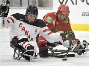 Canada’s Brad Bowden takes the puck away from Russia’s Ilya Popov during the 2015 World Sledge Hockey Challenge at the Leduc Recreation Centre in Leduc on Monday, Feb. 2, 2015.