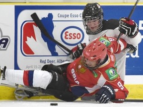Canada’s Tyler McGregor gets hit on the boards by Russia’s Mikhail Chekmarev during the 2015 World Sledge Hockey Challenge at the Leduc Recreation Centre in Leduc on Monday, Feb. 2, 2015.