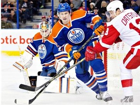 Detroit Red Wings Pavel Datsyuk (13) and Edmonton Oilers Jeff Petry (2) battle for the puck during first period NHL hockey action in Edmonton, Alta., on Tuesday January 6, 2015.