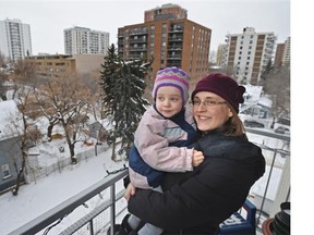 On her balcony, Heather MacKenzie holding daughter Grace, 3, is trying to find out whether parents in her Oliver community and neighbouring communities want to lobby the public school district to put language programs in the area.