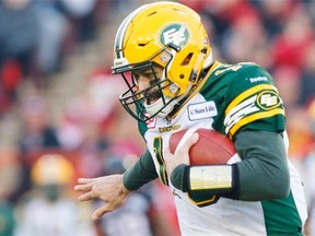 Edmonton Eskimos quarterback Mike Reilly, left, can’t escape the clutches of Calgary Stampeders’ Juwan Simpson during the CFL Western Final action in Calgary on Nov. 23, 2014.