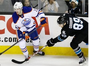 Edmonton Oilers defenceman Justin Schultz, left, and San Jose Sharks left wing Barclay Goodrow, right, reach for the puck during NHL action on Dec. 18, 2014, in San Jose, Calif.