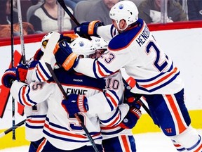 Edmonton Oilers forward Matt Hendricks (23) jumps into the celebration as players mob centre Anton Lander (51) who scored the winning goal during overtime NHL action on Feb. 12, 2015, in Montreal.