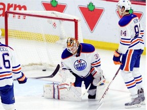 Edmonton Oilers goaltender Viktor Fasth, centre, hangs his head as Teddy Purcell, left, and Oscar Klefborn look on after a goal by the Ottawa Senators during second period NHL hockey action in Ottawa on Saturday, Feb. 14, 2015.