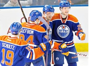 Edmonton Oilers’ Justin Schultz (19), Oscar Klefbom (84), Anton Lander (51) and Matt Fraser (28) celebrate a goal against the Buffalo Sabres during third period NHL hockey action in Edmonton on Jan. 29, 2015.