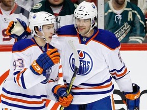 Edmonton Oilers left-wing Benoit Pouliot , right, celebrates with centre Ryan Nugent-Hopkins after Pouliot scored on Minnesota Wild goalie Devan Dubnyk during NHL action in St. Paul, Minn., on Feb. 24, 2015.
