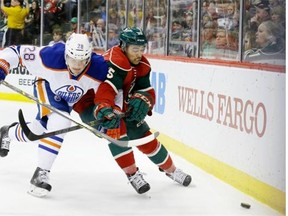 Edmonton Oilers left-winger Matt Fraser and Minnesota Wild defenceman Matt Dumba chase after the puck during Tuesday’s NHL game at St. Paul, Minn.