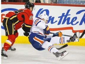Edmonton Oilers’ Matt Hendricks, right, crashes into Calgary Flames’ Jiri Hudler, from the Czech Republic, during second period NHL hockey action in Calgary, Wednesday, Dec. 31, 2014.