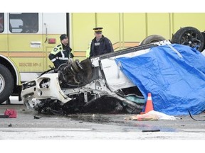 Emergency crews look over the scene of a single-vehicle crash that left three dead on the QEII Highway just south of 41st Avenue SW on Feb. 16, 2015.