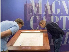 In a file picture taken Nov. 6, 2014, visitors view the Lincoln Cathedral Magna Carta during the opening of an exhibition celebrating the 800th anniversary of the Magna Carta at the Library of Congress in Washington, DC. One of the four surviving original Magna Carta copies will visit Edmonton this year to mark its 800th anniversary.