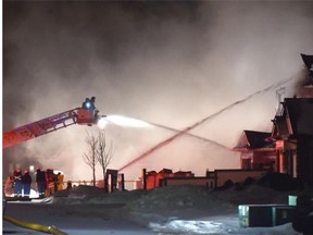 Fire crews pour water onto a duplex under construction that caught fire on Wisteria Lane near Whistler Place in Fort Saskatchewan, February 13, 2015.