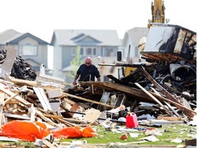 A fire investigator looks through houses damaged in Sunday’s explosion in Lago Lindo in Edmonton on Monday June 21, 2010.