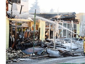 Firefighters put out hotspots during an early morning fire in the historic Roxy Theatre.