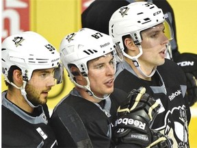 Former Edmonton Oilers forward David Perron, right, watches a part of the Pittsburgh Penguins’ practice on Tuesday at Rexall Place beside defenceman Kris Letang, left, and superstar centre Sidney Crosby.