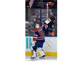 Goalie Ben Scrivens (30) picks up a jersey thrown on the ice and sends it back over the glass as the Edmonton Oilers lose 4-0 to the Minnesota Wild at Rexall Place in Edmonton on February 20, 2015.