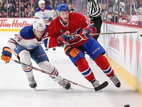Michael Bournival #49 of the Montreal Canadiens skates for the puck along the board while being challenged by Oscar Klefbom #84 of the Edmonton Oilers during NHL action at the Bell Centre on Feb. 12, 2015 in Montreal.