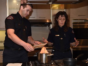 Fire inspectors Nicole Moore and Dean Spronk of  the Fire Prevention Team demonstrate how to put out a grease fire and avoid burn injuries on February 2, 2015.