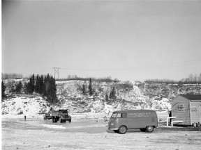 A gravel truck, left, travels on the artificial ice bridge created on the North Saskatchewan River east of the city limits in 1959.