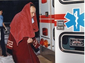 Photographer Con Boland in 1993 gets into an ambulance after being splashed with sulphuric acid when he answered his door.