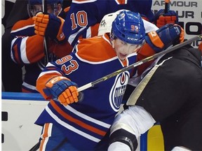 Ryan Nugent-Hopkins of the Edmonton Oilers checks Maxim Lapierre of the Pittsburgh Penguins into the boards during Wednesday’s National Hockey League game at Rexall Place.