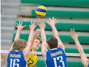 Ryley Barnes of the University of Alberta Golden Bears smashes the ball towards a wall of University of British Columbia Thunderbirds during a Canada West Final Four semifinal match at the Saville Community Sports Centre on Friday.
