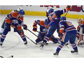 A mad scramble for the puck as the Edmonton Oilers play the Minnesota Wild at Rexall Place in Edmonton on February 20, 2015.