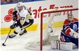 Sidney Crosby (87) circles behind goalie Viktor Fasth (35) as the Edmonton Oilers play the Pittsburgh Penguins  at Rexall Place in Edmonton on February 4, 2015.