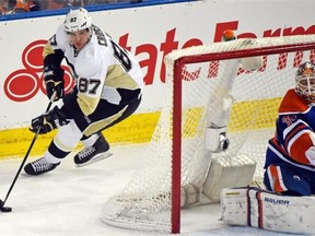 Sidney Crosby (87) circles behind goalie Viktor Fasth (35) as the Edmonton Oilers play the Pittsburgh Penguins  at Rexall Place in Edmonton on February 4, 2015.