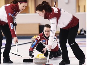 Val Sweeting throws a rock with second Dana Ferguson, right, and lead Rachelle Brown sweeping in front of her during the Alberta women’s curling championship rink’s practice at the Saville Centre on Feb. 10, 2015.