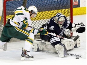 University of Alberta Golden Bears forward Riley Kieser tries to stuff the puck past Mount Royal Cougars goalie Cam Lanagan during Canada West men’s hockey action at Edmonton’s Clare Drake Arena on January 23, 2015.