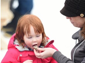 Vivian St. Aubin Kennedy, 3, and her mom Claire enjoyed cooking and eating bannock during the Silver Skate Festival at Edmonton’s Hawrelak Park on Sunday, Feb. 15, 2015.