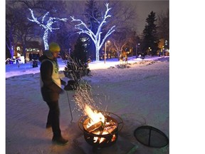 A volunteer stokes the fire during celebrations of the University of Alberta Alumni Association’s 100th anniversary the university held the Green & Glow Winterfest in the Quad area in Edmonton, January 31, 2015. A spectacle of light, fire and snow for this special centenary celebration.