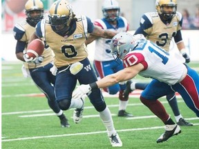 Winnipeg Blue Bombers’ Johnny Sears, left, is tackled by Montreal Alouettes’ Marc-Olivier Brouillette during first half CFL football action in Montreal on Oct. 14, 2013.