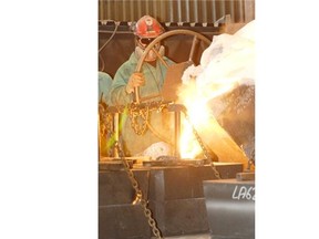 A worker operates a wheel on a hot metal pouring pot while out at Esco in Nisku in this 2007 file photo.