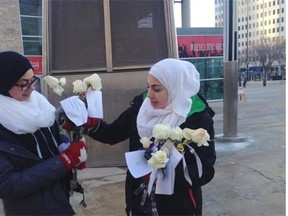 Zaynab Patham,left, 13, and Nadeen Moussa, 13, hand out white roses with the grassroots group Muslims for Peace.